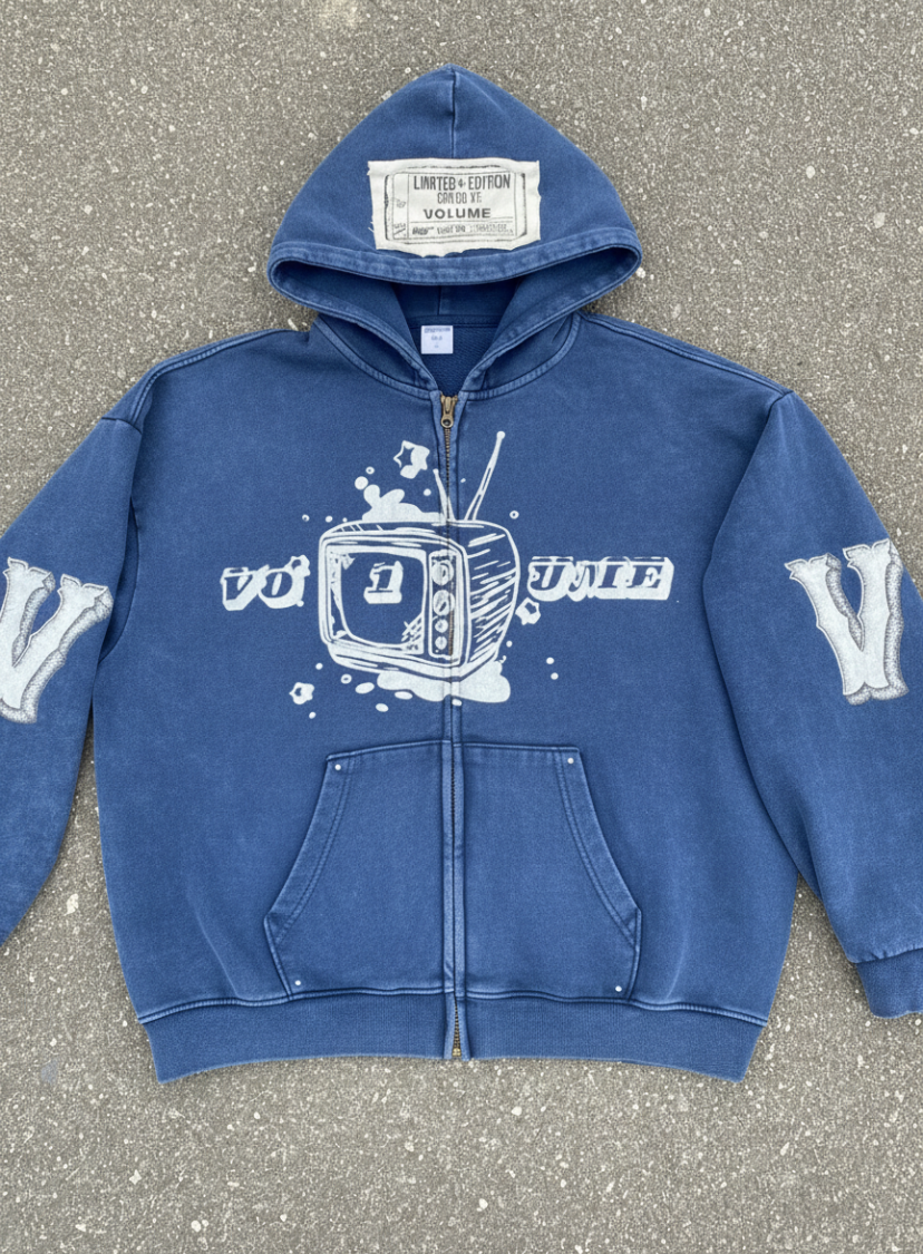 Blue hoodie with white graphics and text on a gray pavement background